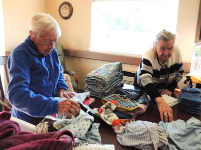 Mary Lee Nash and Helen Furlong folding laundry at Cascade Home